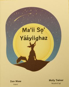 Cover of the book Ma'ii so' yaayiighaz, (Coyote Tosses the Stars). Image is of a night sky, with a large moon and a shooting star. The silhouette of a coyote looking up at the sky is in the foreground.