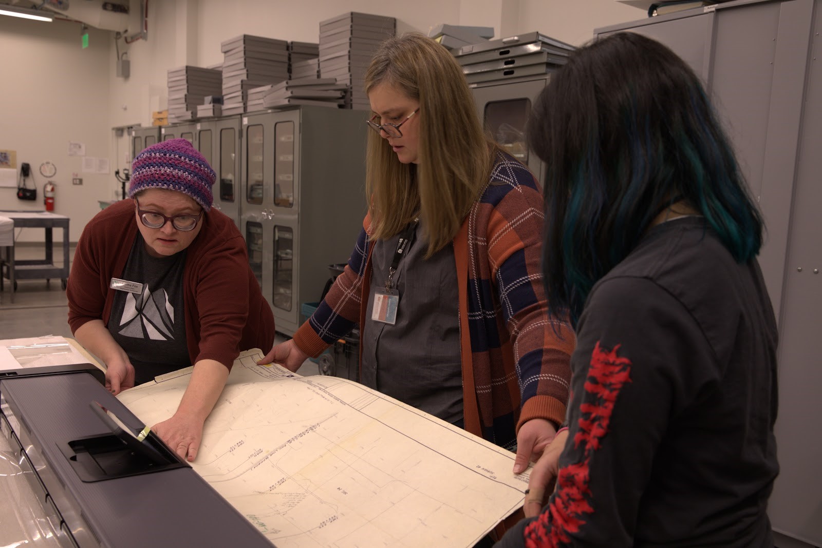 Emma Fox, Katie Saunders, and Jamie Nakano scan an archaeological map using a Contex SD MF 44 scanner designed for large scale documents.