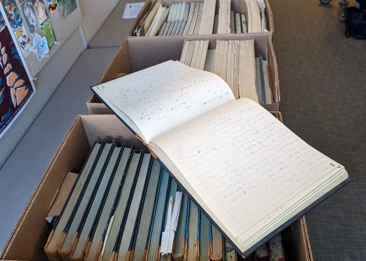 Three boxes of records with an open steno graph notepad on top.