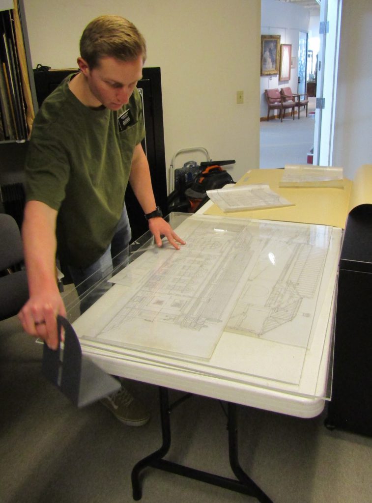 Thomas Stuart flattens Allen’s rolled drawings so that they can be stored unrolled in large flat cabinet drawers.