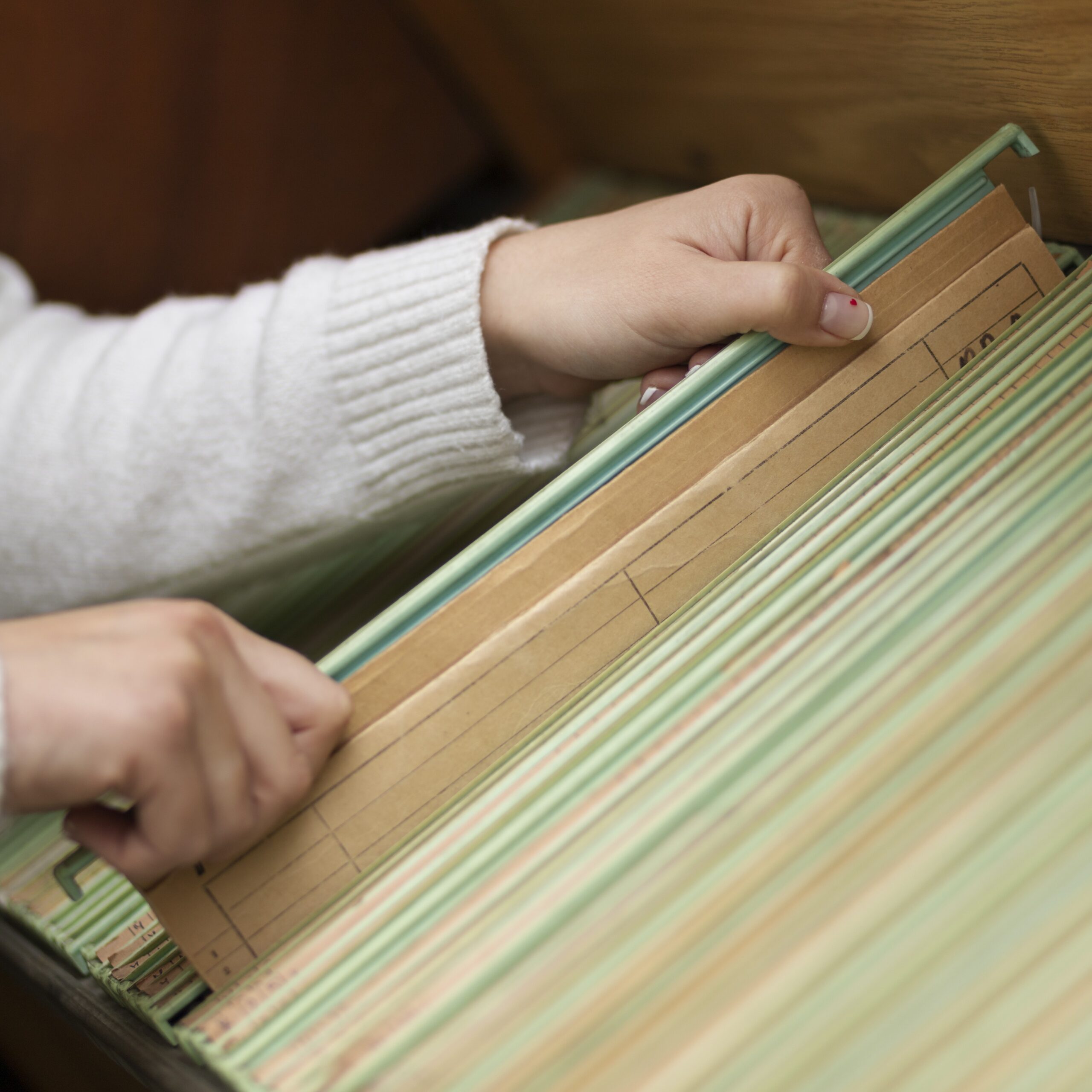 Hands pulling file out of group of files